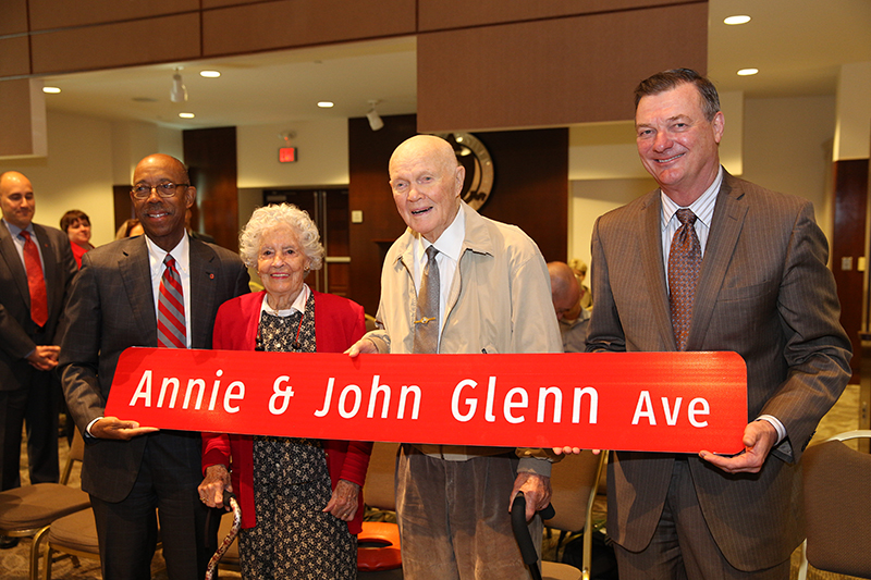 President Michael Drake, Annie Glenn, John Glenn, Board of Trustees Chair Jeffrey Wadsworth pose with the newly named sign of . Credit: Courtesy of OSU