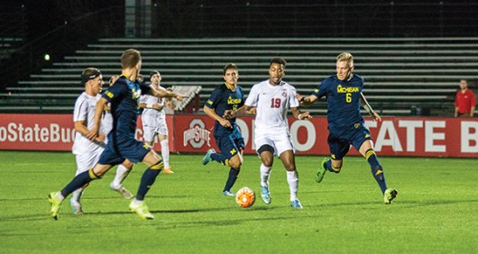 Ohio State sophomore Marcus McCrary (19) dribbles the ball through a group of Michigan players during a soccer game at Jesse Owens Memorial Stadium on Nov. 4, 2015. OSU won 3-1. Credit: Lantern File Photo