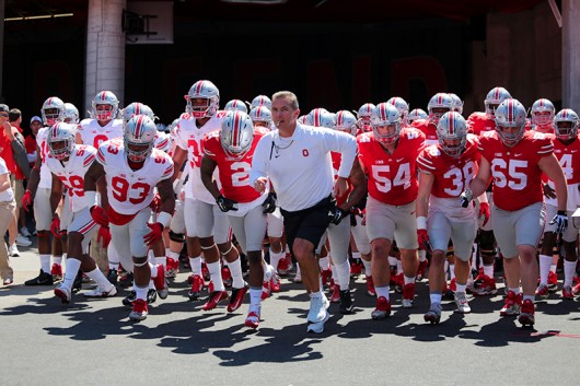 OSU coach Urban Meyer and members of the OSU football team run into the field before the spring game on April 16 at Ohio Stadium. Credit: Lantern file photo