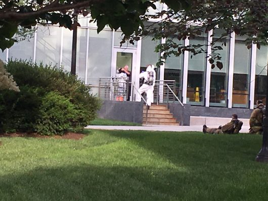 A man enters the Chemical and Biomolecular Engineering and Chemistry building in a white suit.
