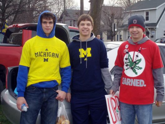 Aaron Tomich (author, right) stands next to brother Matthew (center) and close friend Antonio Carroscia decked in OSU and U of M gear before the 2011 OSU-Michigan game in Ann Arbor, Michigan. Courtesy: Aaron Tomich