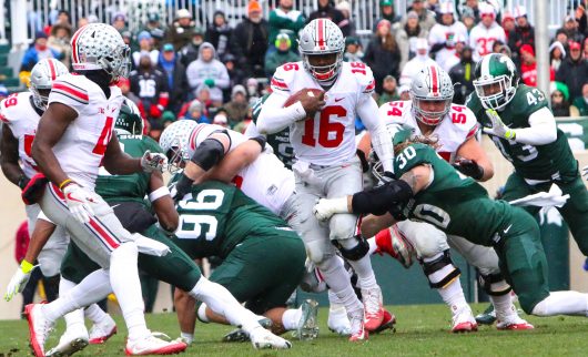 OSU redshirt junior quarterback looks for a lane through the Michigan State defense during the Buckeyes' game against the Spartans. Credit: Alexa Mavrogianis | Photo Editor