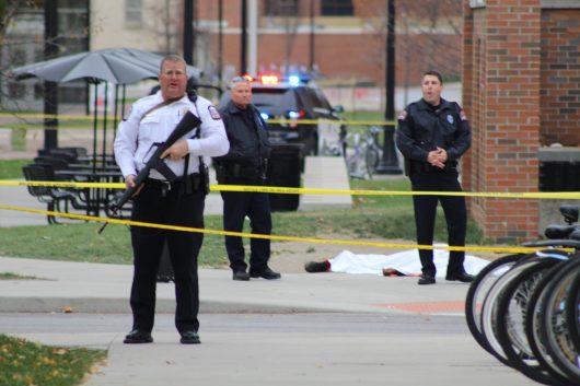 A police officer and two other emergency personnel stand near a body lying near the Chemical and Biomolecular Engineering Chemistry building on North Campus. Credit: Mason Swires | Assistant Photo Editor