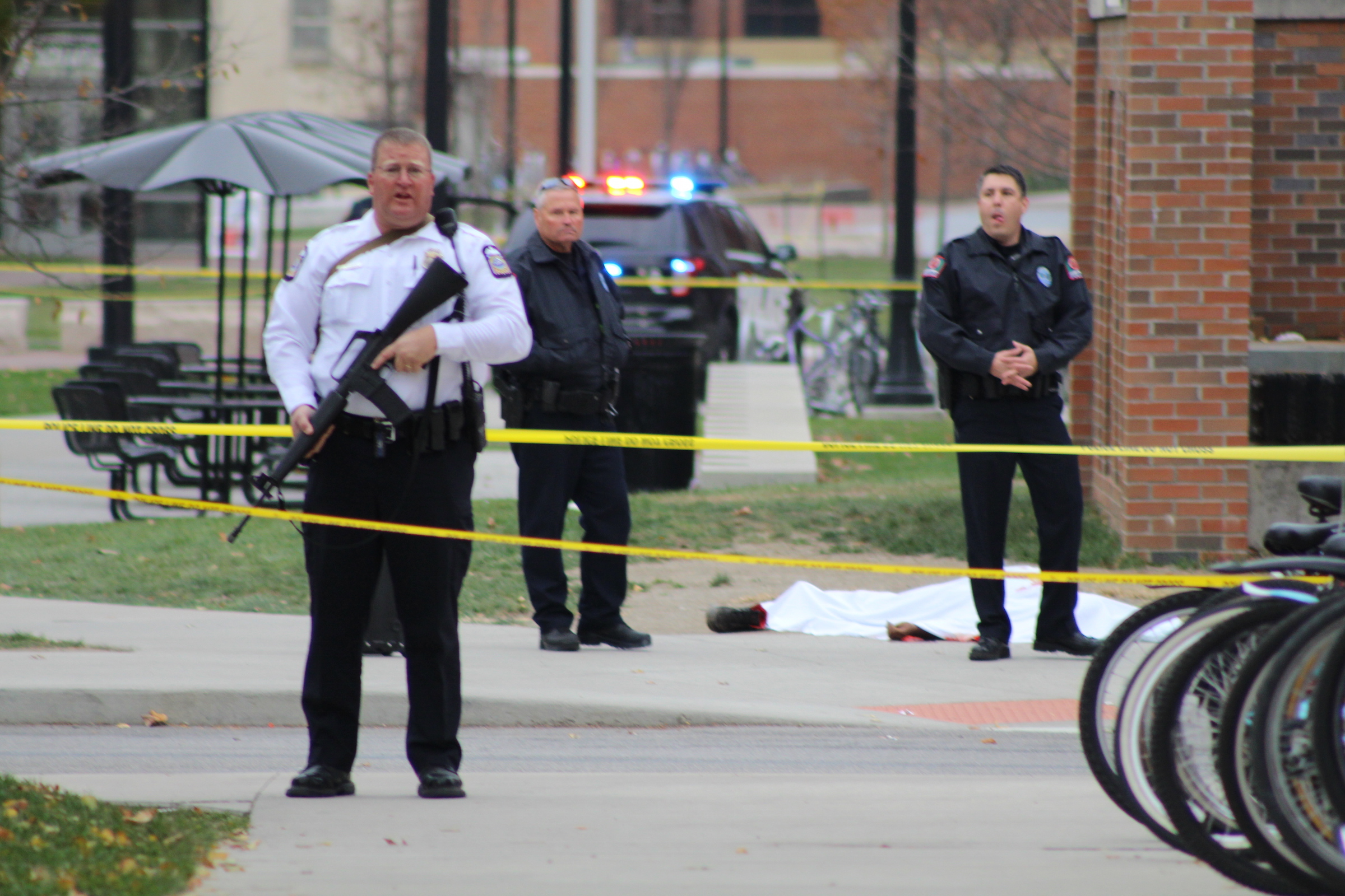 A police officer and two other emergency personnel stand near a body lying near the Chemical and Biomolecular Engineering Chemistry building on North Campus. Credit: Mason Swires | Assistant Photo Editor