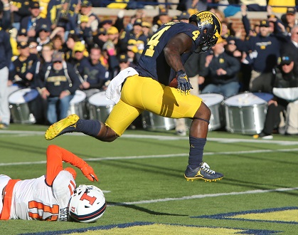 Michigan running back De'Veon Smith (4) goes over Illinois defensive back Stanley Green for a touchdown on Saturday, Oct. 22, 2016, at Michigan Stadium in Ann Arbor, Mich. Michigan won, 41-8. Credit: Courtesy of TNS