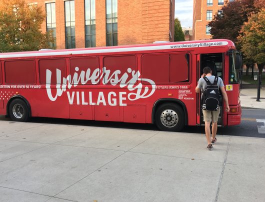 A student boards the University Village bus that transports residents of the complex to and from campus. Credit: Mitch Hooper | Engagement Editor